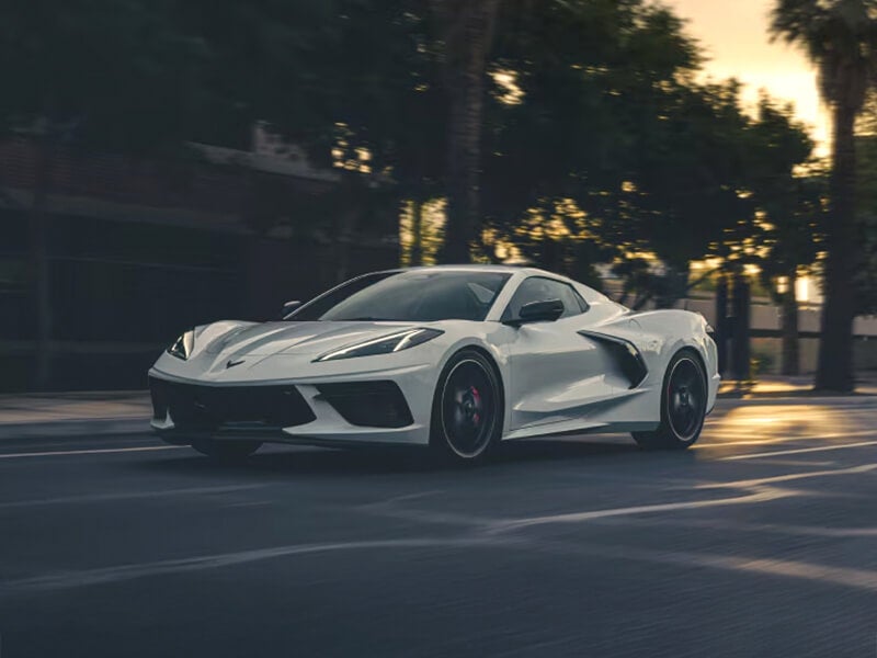White Corvette driving on residential street