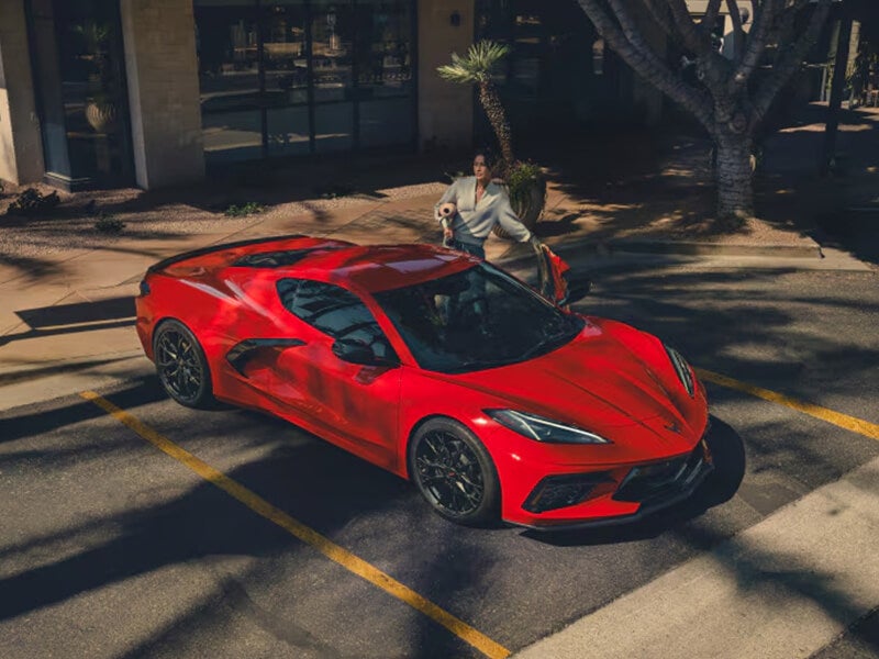Woman exiting red Corvette